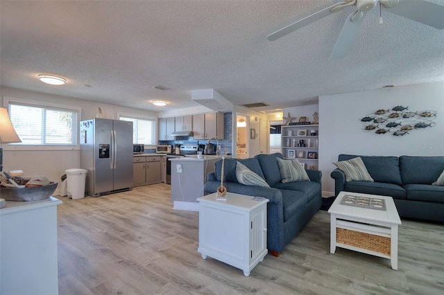 6622 Seaview Blvd, Hudson, FL 34667 - living area with a textured ceiling, light wood-style flooring, and ceiling fan