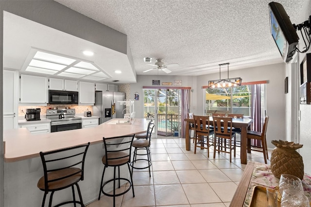 13469 Pia Ct, Spring Hill, FL 34609 - kitchen with light countertops, stainless steel appliances, a sink, and a wealth of natural light
