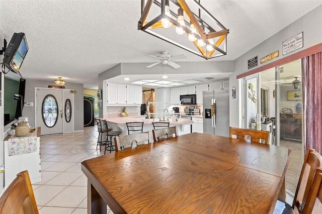 13469 Pia Ct, Spring Hill, FL 34609 - dining area with light tile patterned floors, ceiling fan, and a textured ceiling