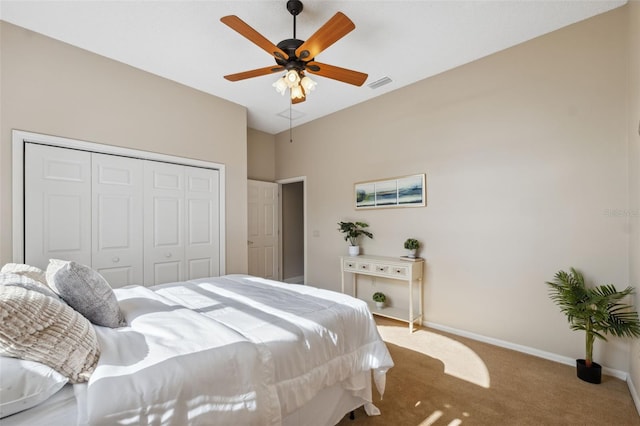 carpeted bedroom featuring baseboards, visible vents, ceiling fan, and a closet