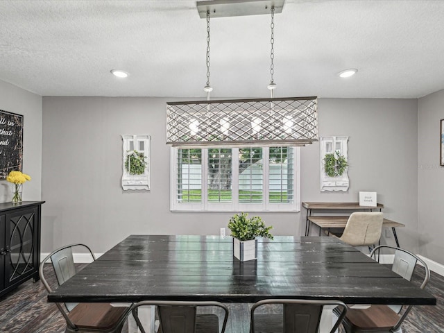 dining space with recessed lighting, a textured ceiling, and dark wood-type flooring