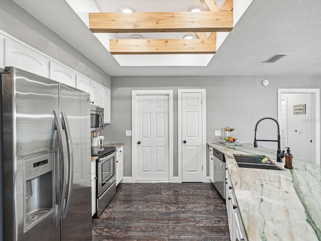 kitchen with white cabinetry, a sink, visible vents, stainless steel appliances, and dark wood-type flooring