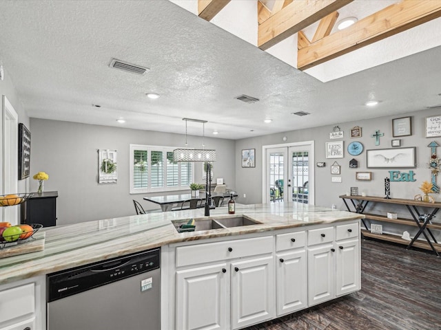 kitchen featuring white cabinets, dishwashing machine, visible vents, and a sink