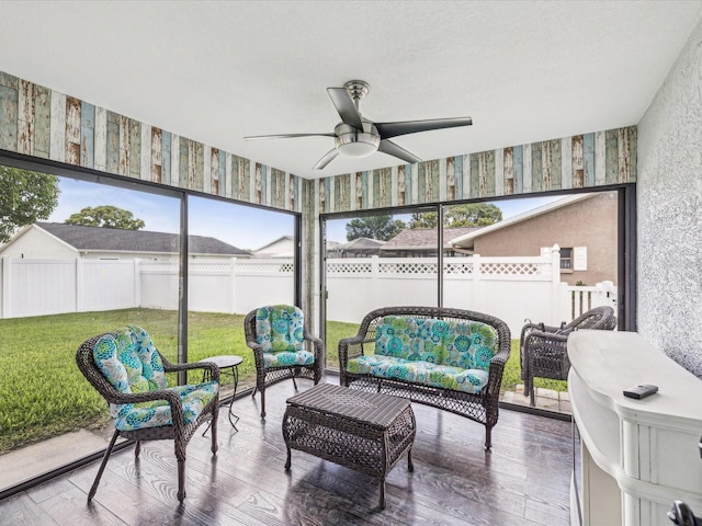 sunroom / solarium featuring a healthy amount of sunlight, a ceiling fan, and an outdoor living space