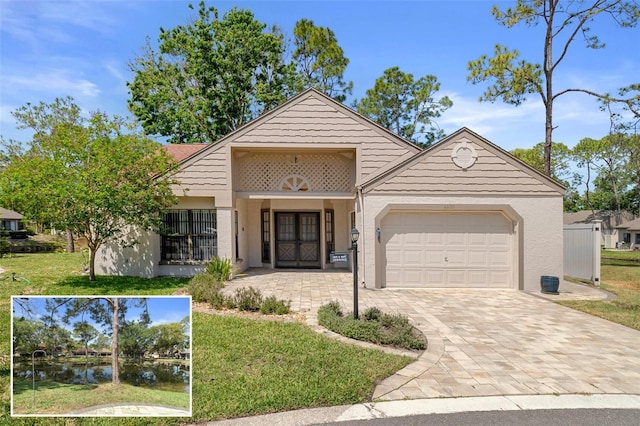 view of front of property with stucco siding, a front lawn, decorative driveway, and an attached garage