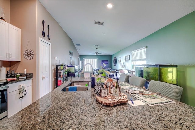 680 Argyll Dr, Spring Hill, FL 34609 - kitchen with white cabinets, a sink, dark stone countertops, open floor plan, and visible vents