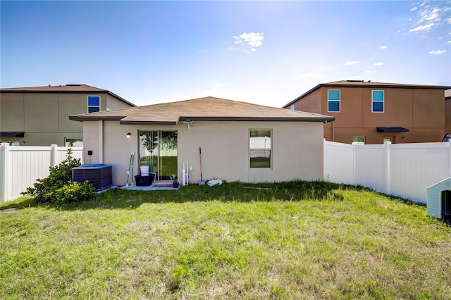 680 Argyll Dr, Spring Hill, FL 34609 - rear view of house with a fenced backyard, central AC, a lawn, a shingled roof, and stucco siding