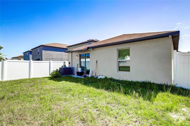 680 Argyll Dr, Spring Hill, FL 34609 - back of house featuring fence, central AC unit, a yard, and stucco siding