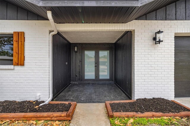 property entrance with brick siding and french doors