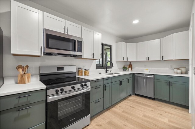 kitchen with stainless steel appliances, light countertops, and a sink