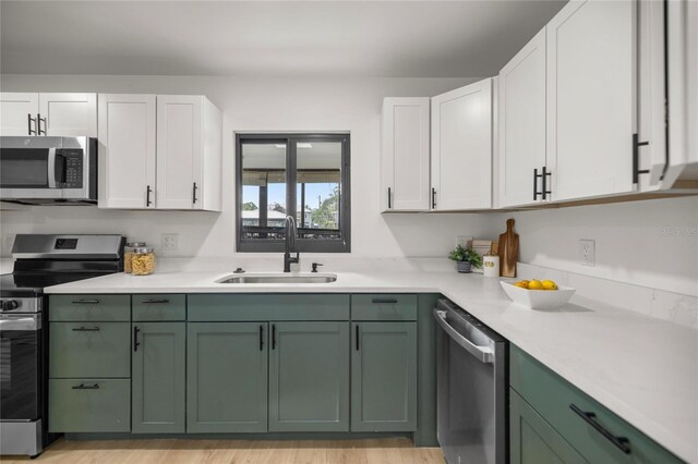 kitchen featuring green cabinetry, stainless steel appliances, and a sink