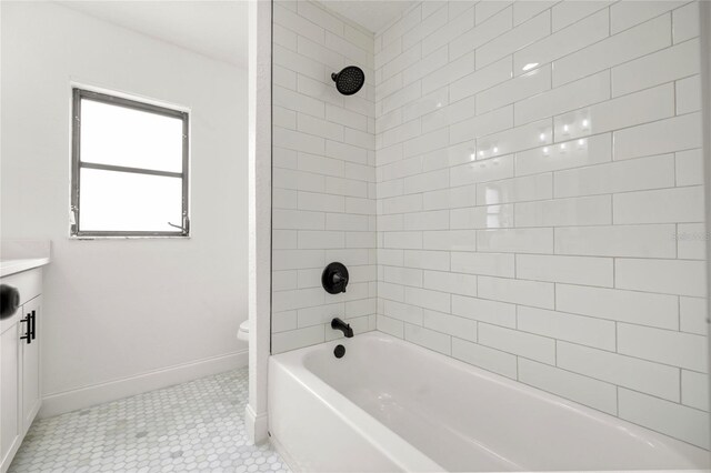 full bathroom featuring toilet, vanity, tub / shower combination, baseboards, and tile patterned flooring