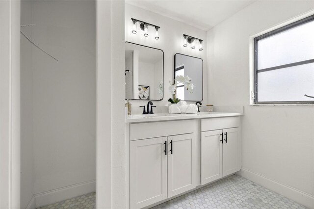 full bathroom with baseboards, a sink, and double vanity