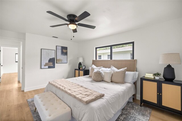 bedroom with baseboards, visible vents, light wood-style floors, and ceiling fan