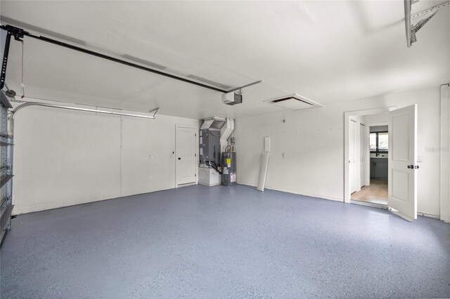 garage with a garage door opener, heating unit, and electric water heater