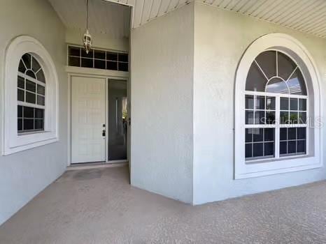 9237 Penelope Dr, Weeki Wachee, FL 34613 - doorway to property featuring stucco siding