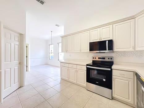 9237 Penelope Dr, Weeki Wachee, FL 34613 - kitchen with stainless steel appliances, light countertops, visible vents, light tile patterned floors, and pendant lighting