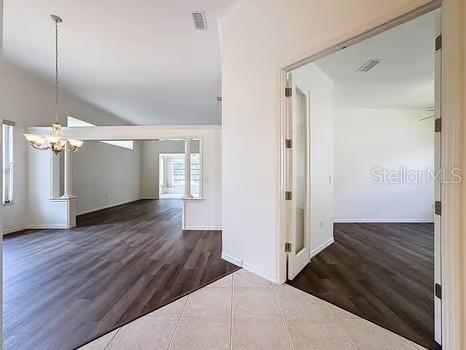 9237 Penelope Dr, Weeki Wachee, FL 34613 - interior space with a chandelier, wood finished floors, visible vents, and baseboards