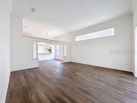 9237 Penelope Dr, Weeki Wachee, FL 34613 - unfurnished living room featuring wood finished floors