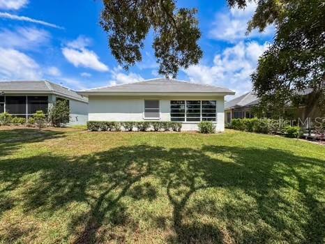 9237 Penelope Dr, Weeki Wachee, FL 34613 - back of property with a lawn and a sunroom