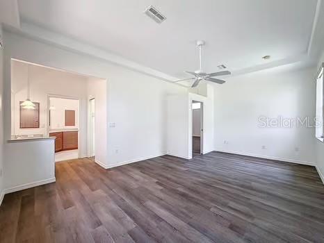 9237 Penelope Dr, Weeki Wachee, FL 34613 - unfurnished bedroom featuring baseboards, a ceiling fan, visible vents, and dark wood-type flooring