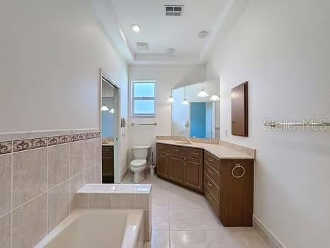 9237 Penelope Dr, Weeki Wachee, FL 34613 - bathroom with a bath, vanity, toilet, tile patterned flooring, and visible vents