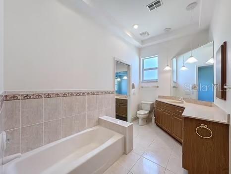 9237 Penelope Dr, Weeki Wachee, FL 34613 - full bath featuring tile patterned flooring, visible vents, toilet, vanity, and a garden tub