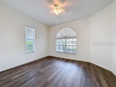 9237 Penelope Dr, Weeki Wachee, FL 34613 - spare room featuring baseboards, a ceiling fan, and dark wood-style floors