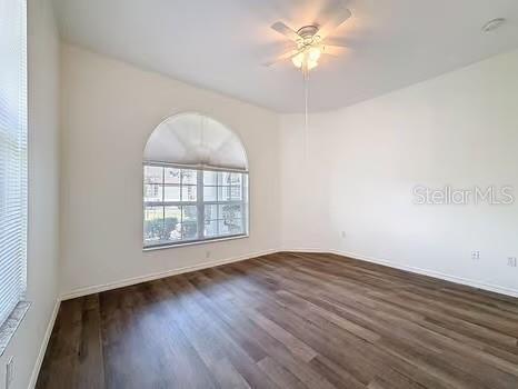 9237 Penelope Dr, Weeki Wachee, FL 34613 - unfurnished room featuring baseboards, dark wood-type flooring, and ceiling fan