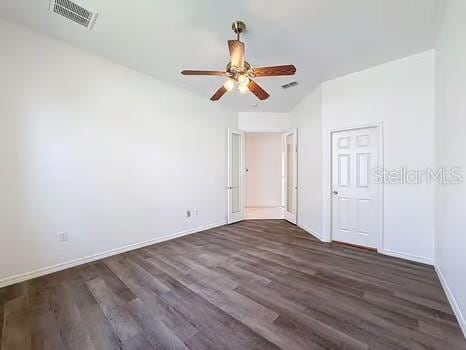 9237 Penelope Dr, Weeki Wachee, FL 34613 - unfurnished bedroom featuring dark wood-type flooring, visible vents, and baseboards