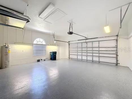 9237 Penelope Dr, Weeki Wachee, FL 34613 - garage with water heater and a garage door opener
