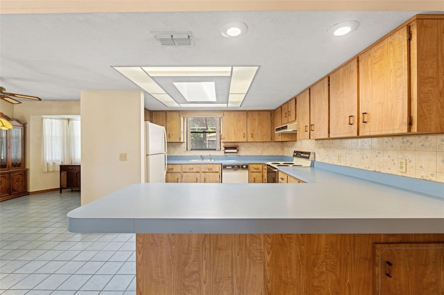3029 Harrow Rd, Spring Hill, FL 34606 - kitchen with a sink, light countertops, a peninsula, under cabinet range hood, and white appliances