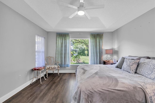 14105 Agua Clara Dr, Hudson, FL 34667 - bedroom featuring a tray ceiling, wood finished floors, a textured ceiling, and ceiling fan