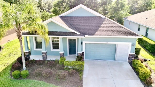 single story home with driveway, stone siding, a shingled roof, a porch, and a garage