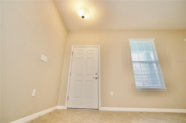 unfurnished room featuring baseboards and light tile patterned flooring