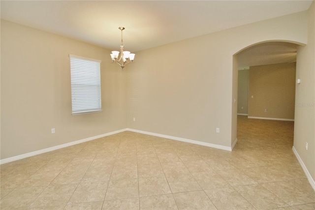 spare room with arched walkways, baseboards, a notable chandelier, and light tile patterned floors