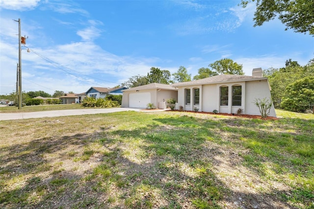 ranch-style house featuring a chimney, stucco siding, an attached garage, concrete driveway, and a front yard