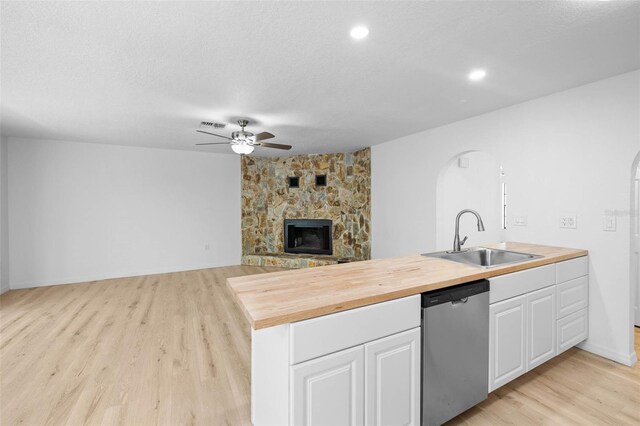 kitchen featuring a sink, wood counters, dishwasher, ceiling fan, and arched walkways