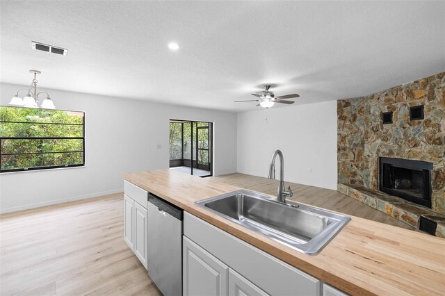 kitchen featuring butcher block countertops, a sink, open floor plan, dishwasher, and visible vents