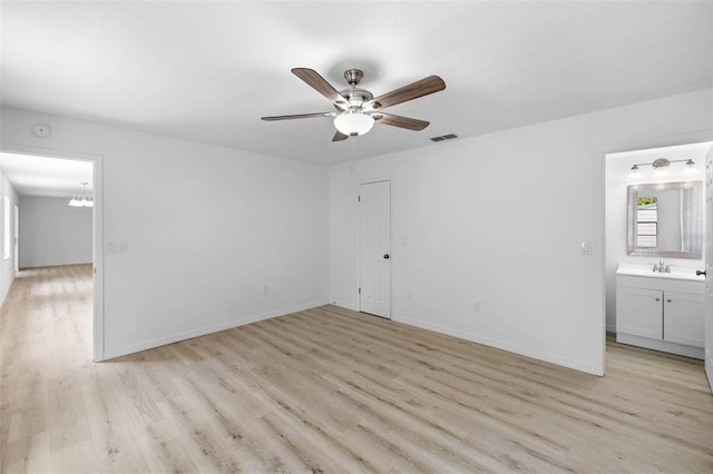 unfurnished bedroom featuring light wood-style flooring, connected bathroom, baseboards, and a sink