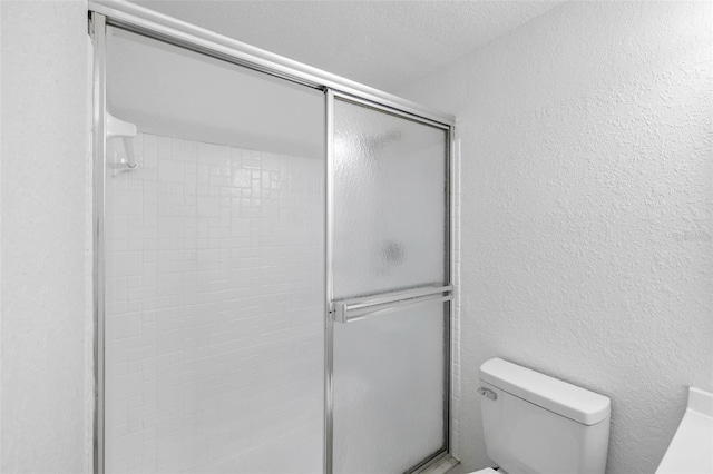 bathroom featuring a shower stall and toilet