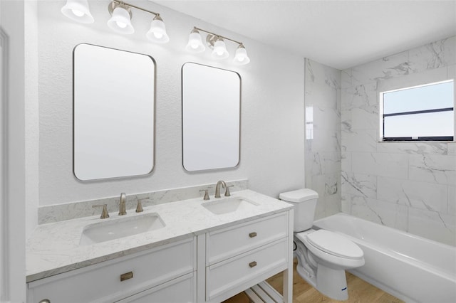 full bath with double vanity, toilet, wood finished floors, and a sink