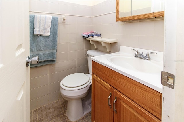 bathroom with tile walls, tile patterned flooring, vanity, and toilet
