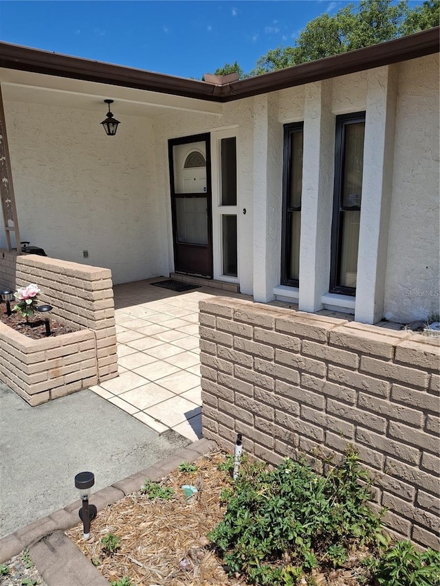 7715 Gulf Highlands Dr, Port Richey, FL 34668 - entrance to property featuring stucco siding and a patio area
