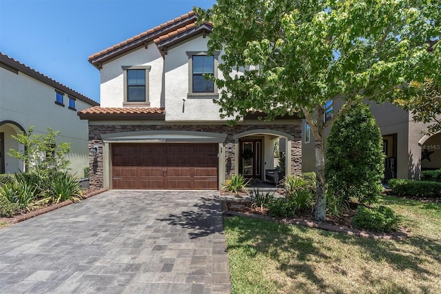 12889 Burns Dr, Odessa, FL 33556 - mediterranean / spanish-style home featuring a tile roof, an attached garage, stucco siding, and decorative driveway