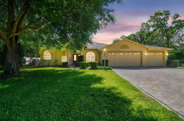 18502 Winding Oaks Blvd, Hudson, FL 34667 - view of front of home featuring decorative driveway, a garage, stucco siding, and a front yard