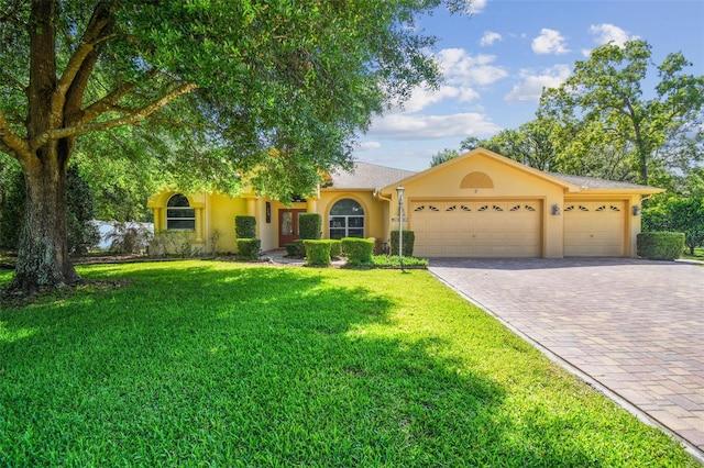 18502 Winding Oaks Blvd, Hudson, FL 34667 - view of front facade featuring an attached garage, decorative driveway, stucco siding, and a front yard
