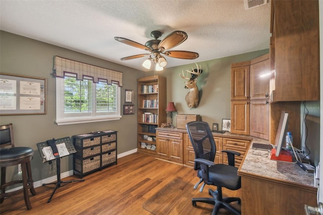 18502 Winding Oaks Blvd, Hudson, FL 34667 - office area featuring visible vents, baseboards, dark wood-type flooring, a textured ceiling, and a ceiling fan