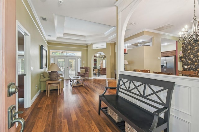 18502 Winding Oaks Blvd, Hudson, FL 34667 - foyer entrance featuring visible vents, crown molding, arched walkways, a tray ceiling, and dark wood-type flooring