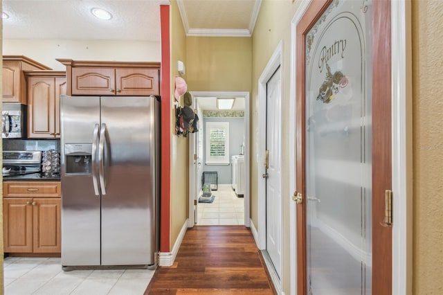 18502 Winding Oaks Blvd, Hudson, FL 34667 - kitchen featuring dark countertops, appliances with stainless steel finishes, ornamental molding, and light tile patterned floors